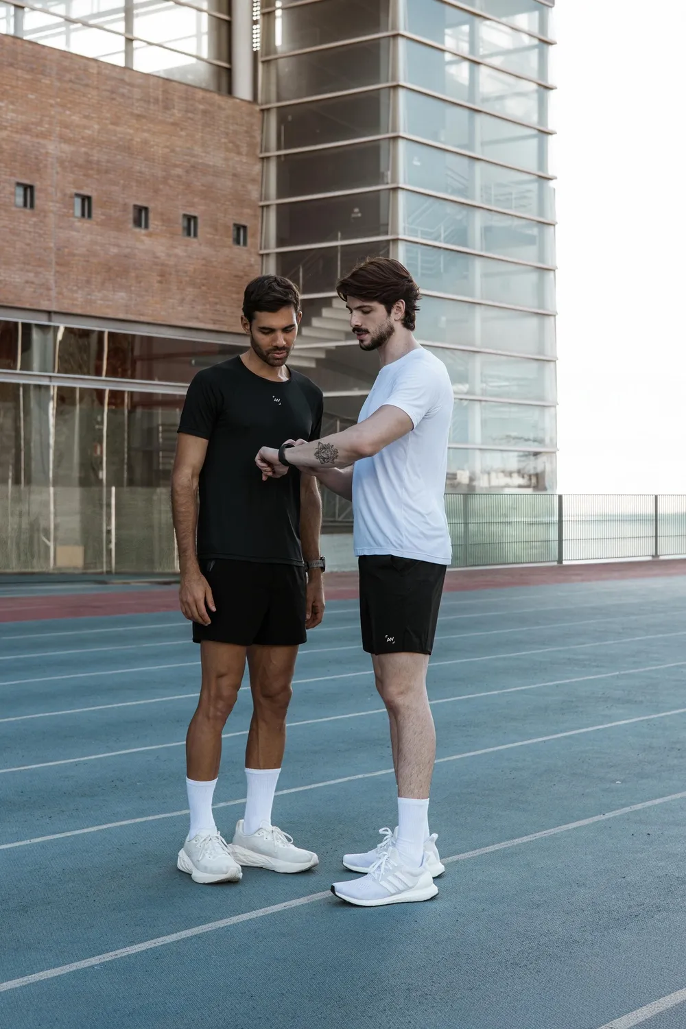 A runner and a coach checking watch splits on a track